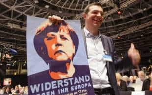 tsipras con un poster della merkel