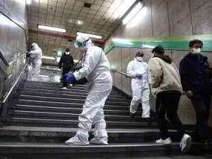 operatori con equipaggiamento protettivo disinfettano la metro a seul