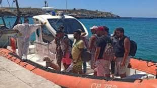 migranti con barboncino vestiti da turisti